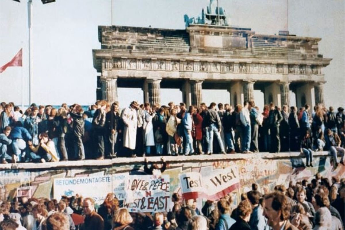 Menschenmengen auf der Berliner Mauer Ende 1989 nach dem historischen Mauerfall.