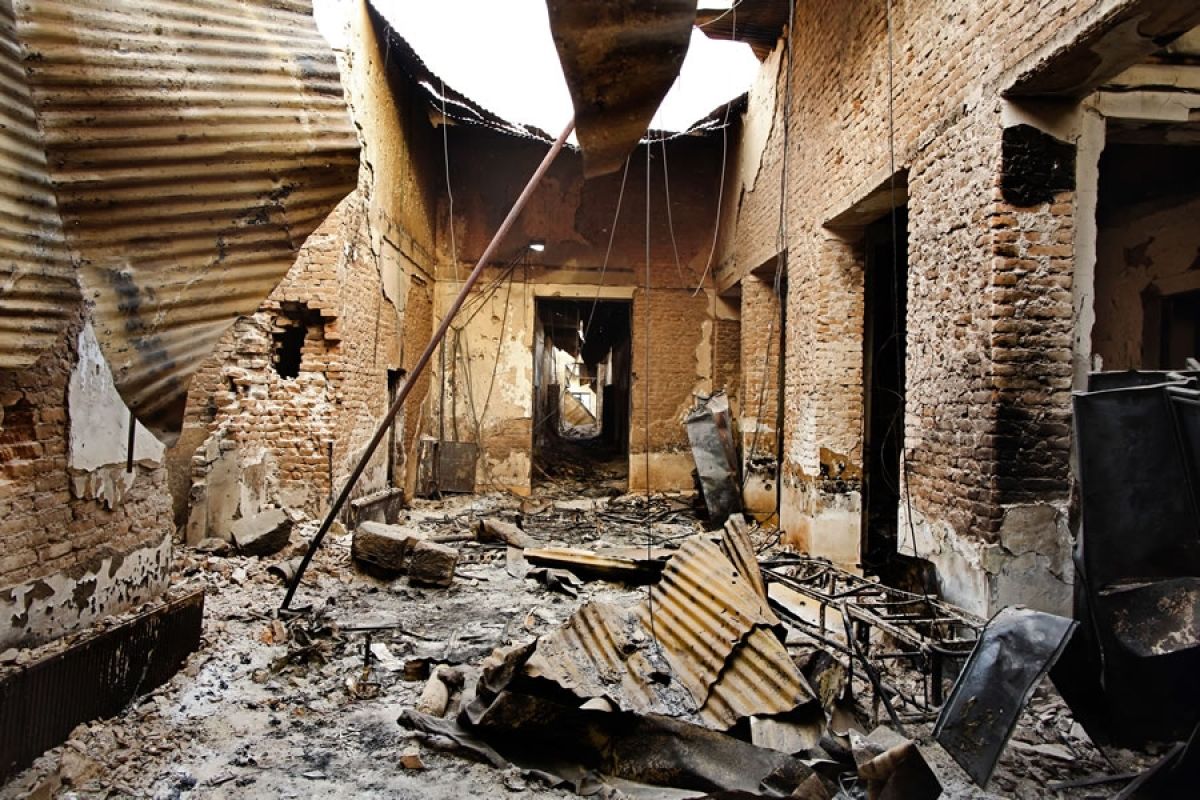 Iron roofing and rubble litter a corridor in the MSF Kunduz