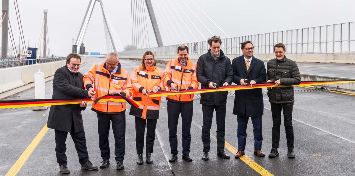 Eröffnung des 1. Teilstücks der neuen Rheinbrücke Leverkusen Foto: Durchschneiden des Bandes. Von Links nach rechts im Bild: Oliver Krischer (Minister für Naturschutz und Verkehr in Nordrhein Westfalen), Thomas Ganz (Leiter der Autobahn GmbH, Niederlassung Rheinland), Nicole Ritterbusch (Leiterin Rheinbrücken der Autobahn GmbH, Niederlassung Rheinland), Michael Güntner (Vorsitzender Geschäftsführer der Autobahn GmbH des Bundes), Hendrik Wüst (Ministerpräsident von Nordrhein-Westfalen), Oliver Luksic (Staatssekretär und Aufsichtsratsvorsitzender der Autobahn GmbH des Bundes) und Karl Lauterbach (Bundesgesundheitsminister und Bundestagsabgeordneter im Wahlkreis Leverkusen)
